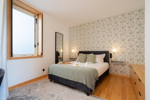 a bedroom with a large bed and a window at Luxurious Bright Flats - Ace Location in Porto