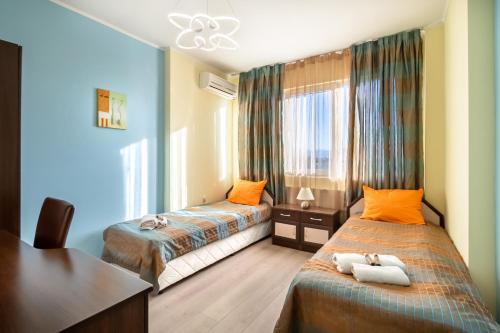 a hotel room with two beds and a desk at Apartments Rosina in Plovdiv