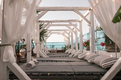 a white pergola with pillows on a patio at Hotel Parthenon Rodos city in Rhodes Town