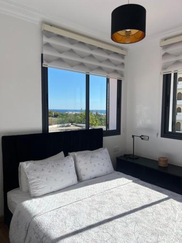 ein Schlafzimmer mit einem großen Bett und einem großen Fenster in der Unterkunft Coin Confort 2 chambres de luxe avec piscine in Tétouan