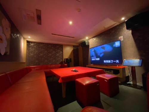 sala de estar con mesa roja y TV de pantalla plana en Kenting Southern Dream Resort, en Kenting