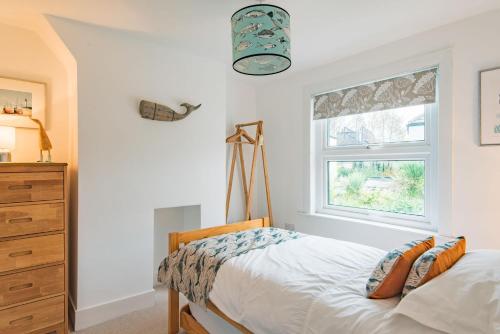 Samphire Cottage by Bloom Stays في برودستيرز: غرفة نوم بسرير ونافذة