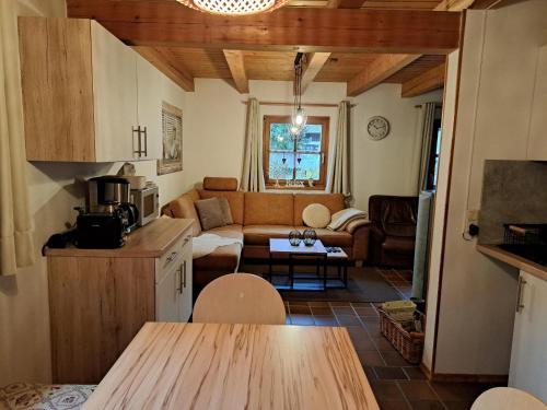 eine Küche und ein Wohnzimmer mit einem Sofa in der Unterkunft Ferienhaus MARIA im Waldferiendorf in Regen