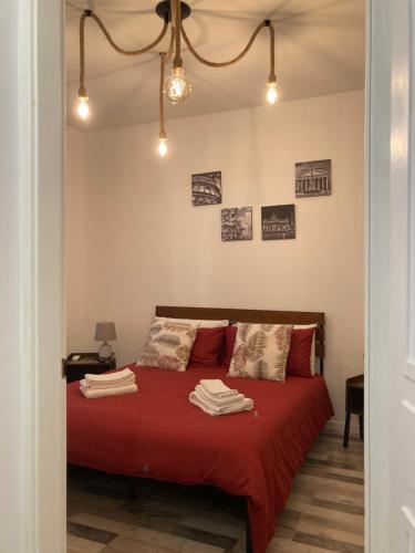 - une chambre avec un lit rouge et des serviettes dans l'établissement La casa dell’Appio, à Rome