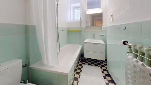 a bathroom with a tub and a toilet and a sink at Apartment Chavallera 5 in St. Moritz