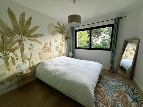 ein Schlafzimmer mit einem großen weißen Bett und einem Fenster in der Unterkunft Vue mer Bretagne Villa d'architecte in Plérin