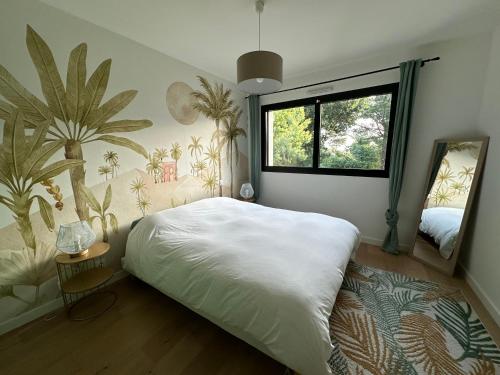 una camera da letto con un grande letto bianco e una finestra di Vue mer Bretagne Villa d'architecte a Plérin