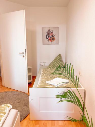 Habitación pequeña con cama y planta en 2 Zimmer City Apartment mit Terrasse und Tiefgaragenstellplatz in Zentrum von Leipzig, en Leipzig