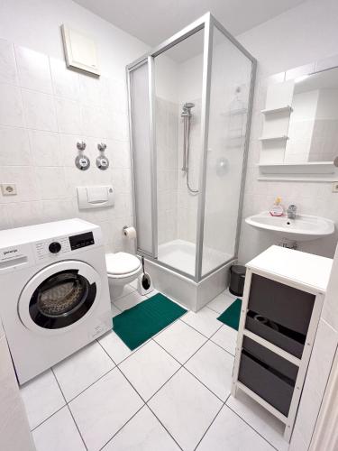 y baño con ducha y lavadora. en 2 Zimmer City Apartment mit Terrasse und Tiefgaragenstellplatz in Zentrum von Leipzig, en Leipzig