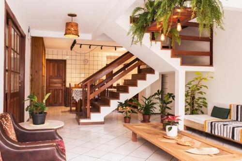 un salon avec un escalier et des plantes en pot dans l'établissement Nômades Beach Hostel, à Florianópolis