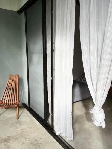 a room with a sliding glass door and a chair at Pachamama Tropical Garden Lodge in Carmen