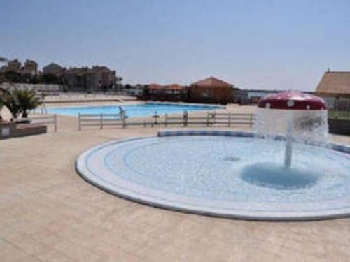 une grande piscine d'eau avec une fontaine. dans l'établissement Magnifique Appartement t2, au Barcarès