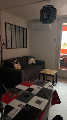 un salon avec un canapé et une table dans l'établissement Magnifique Appartement t2, au Barcarès