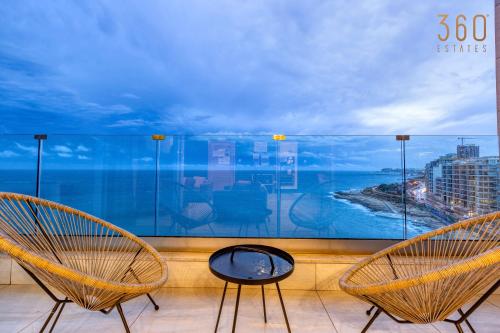 two chairs on a balcony with a view of the ocean at Stunning, Seafront 3BR home in the heart of Sliema by 360 Estates in Sliema