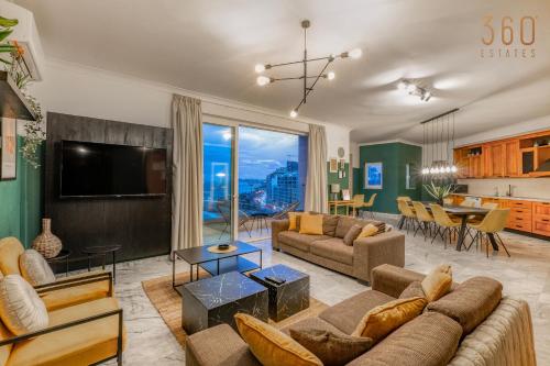 a living room with a couch and a tv at Stunning, Seafront 3BR home in the heart of Sliema by 360 Estates in Sliema