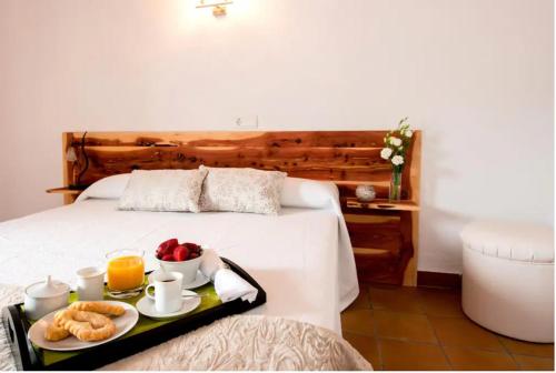 una habitación de hotel con una bandeja de comida en una cama en Can Rosch, en Can Furnet