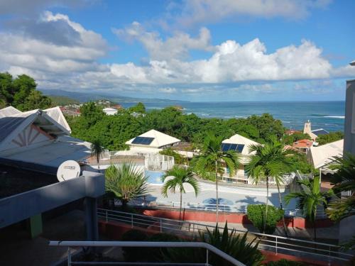 a view of a resort with a swimming pool and the ocean at Chez Valérie et Pascal in La Trinité