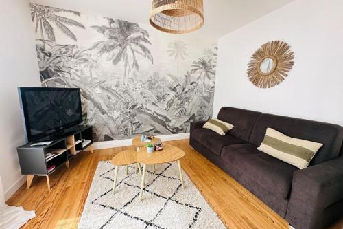 een woonkamer met een bank en een tafel bij Appartement cosy - centre-ville in Lorient