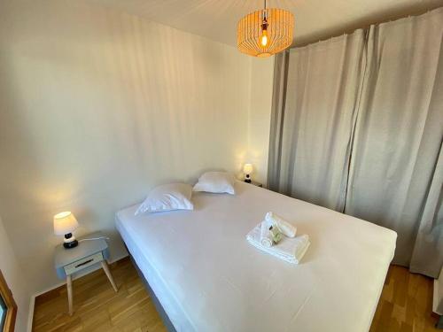 um quarto com uma cama branca e 2 almofadas em Grand studio, belle terrasse avec vue em Nantes