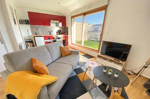 uma sala de estar com um sofá e uma mesa em Grand studio, belle terrasse avec vue em Nantes