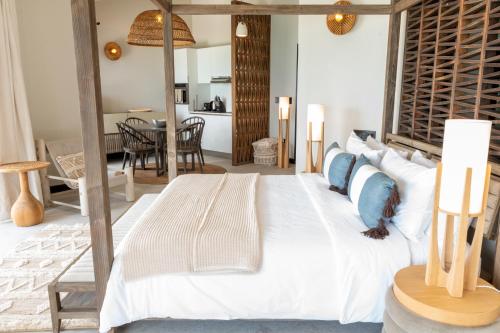 1 Schlafzimmer mit einem großen Bett und einem Esszimmer in der Unterkunft Tamarind Hills Resort & Villas in Bolans