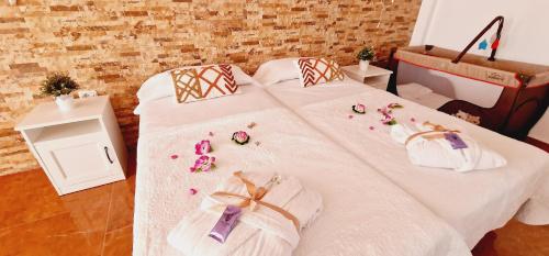 un letto con lenzuola bianche e fiori sopra di Bright 4 bedroom Villa, Pool and Tennis court a Playa Paraiso