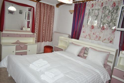 a bedroom with a large white bed and a mirror at Countryside Home in Gómfoi