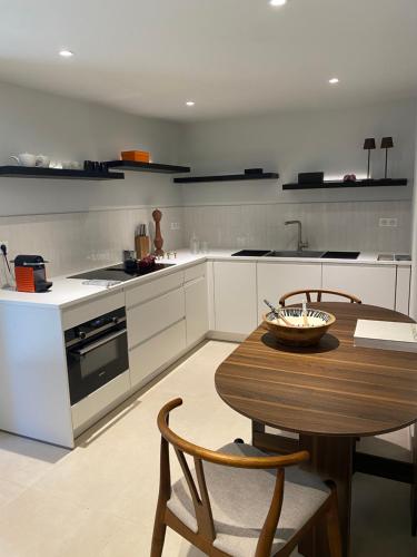 a kitchen with a wooden table and a table and chairs at DURANCE in La Brillanne