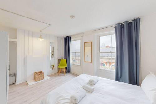 1 dormitorio con 1 cama blanca y 2 ventanas en Modern 2 Bed Maisonette in Farringdon Barbican en Londres