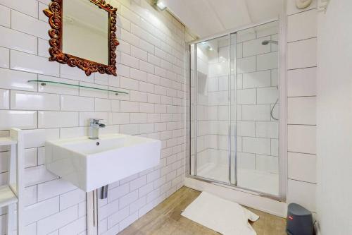 a white bathroom with a sink and a shower at Modern 2 Bed Maisonette in Farringdon Barbican in London