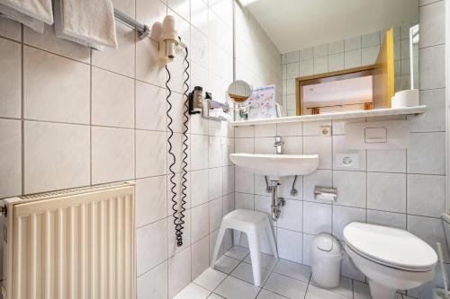Baño blanco con lavabo y aseo en Landschloss Ernestgrün Apartment309, 