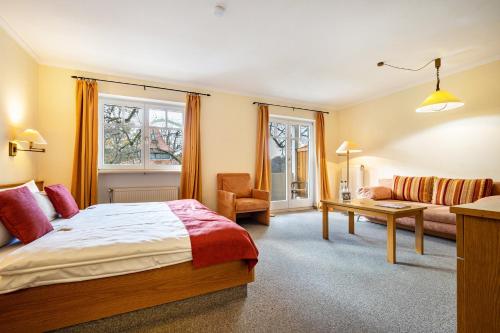 Habitación de hotel con cama y sofá en Landschloss Ernestgrün Apartment309, 