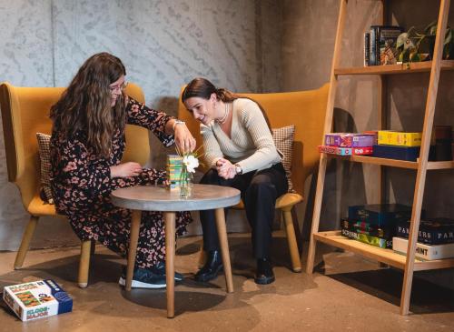 two women sitting around a table with flowers at Hotel GUESTapart in Aarhus