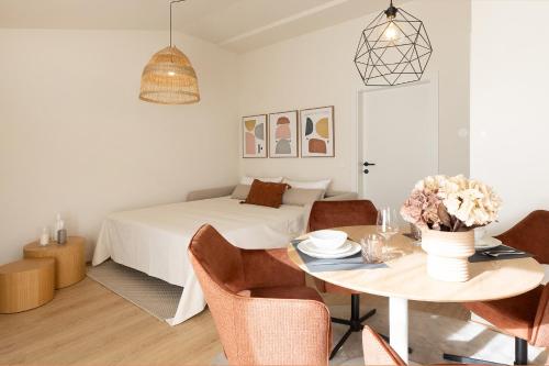a bedroom with a bed and a table and chairs at Kolibri Apartment in Elsbethen
