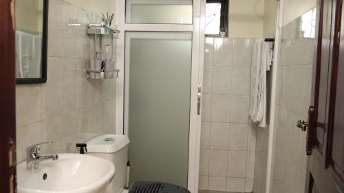 a bathroom with a sink and a toilet and a shower at Premier Suites Kyanja in Kampala