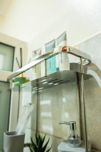 a bathroom sink with a glass shelf above it at Premier Suites Kyanja in Kampala