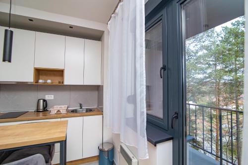 a kitchen with white cabinets and a large window at Titova Vila Zlatibor in Zlatibor