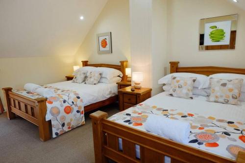 1 dormitorio con 2 camas y 2 lámparas. en The Ash Cottage, en Brecon