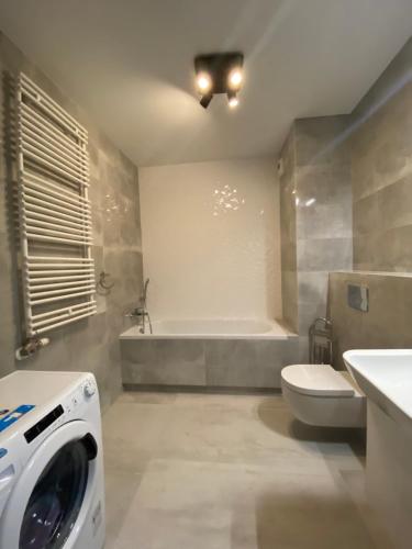 łazienka z toaletą i pralką w obiekcie Apartamenty Fuzja - Komfortowe Mieszkania Blisko Centrum Łodzi w Łodzi