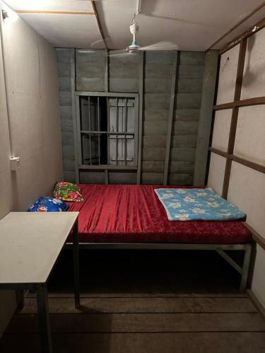 a small room with a red bed and a window at Khmer rooms in Siem Reap