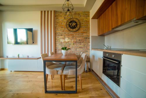 a kitchen with a table and chairs and a brick wall at Titova Vila Zlatibor in Zlatibor