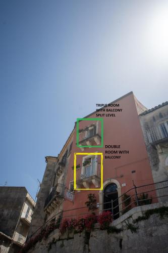 a building with a sign on the side of it at Bed and Breakfast Terra del Sole Ibla in Ragusa