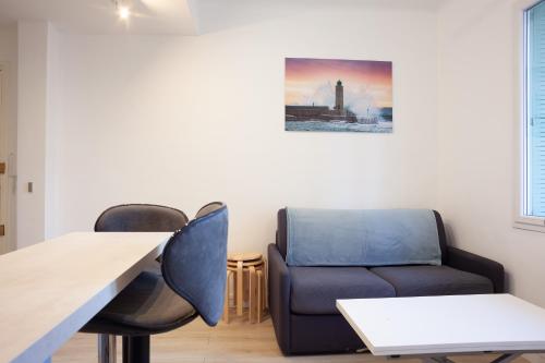 ein Wohnzimmer mit einem Sofa, einem Tisch und Stühlen in der Unterkunft Appartement Cassis in Cassis