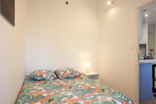 a bed with two pillows in a small bedroom at Appartement Cassis in Cassis