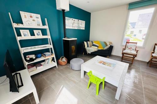 ein Wohnzimmer mit einem weißen Tisch und grünen Stühlen in der Unterkunft Jolie maison de pêcheur - Mer in Riantec