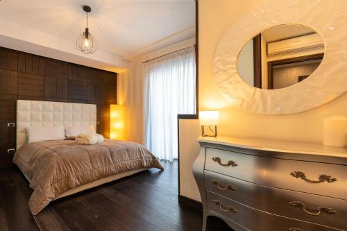 una camera da letto con un letto e un comò con uno specchio di Nettuno's Suite a Napoli