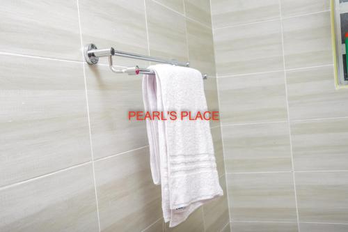 a bathroom with a white towel hanging on a wall at Pearl's Place in Meru