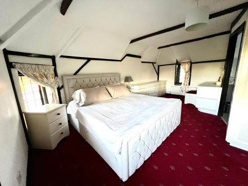 1 dormitorio con cama blanca y alfombra roja en Reads Cottage en Waterlooville