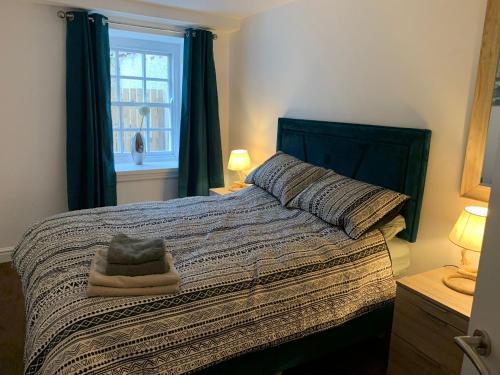 a bedroom with a bed with a blanket and a window at One Bedroom Apartment in Bethesda in Bangor