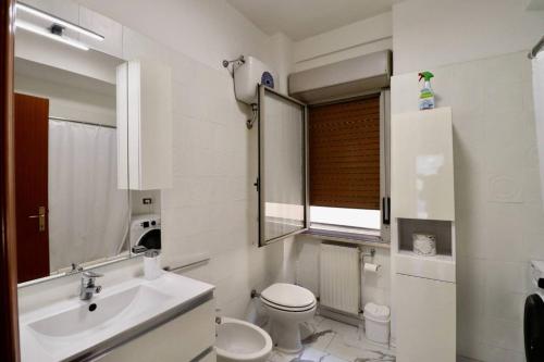a bathroom with a sink and a toilet and a mirror at Casa Stazione Magliana in Rome